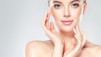 Beautiful Young Woman with Clean Fresh Skin touch own face . Facial ...